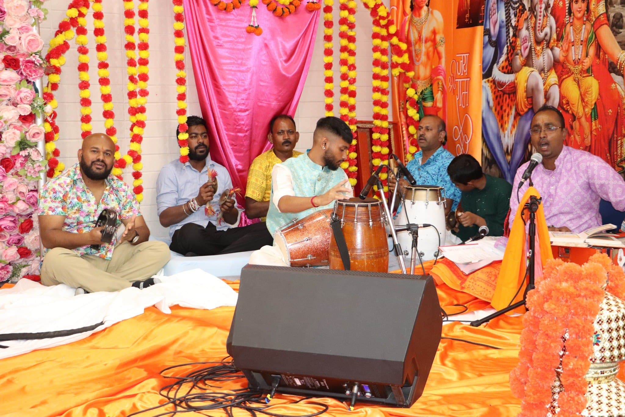 Musicians playing harmonium and dholak during the kirtan