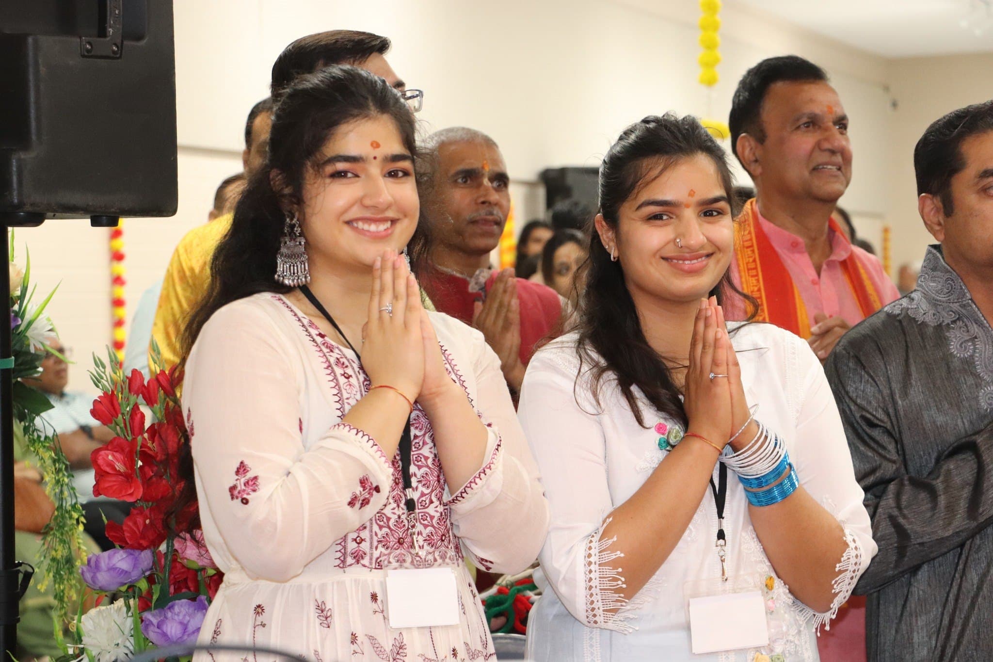 Two young volunteers greet the sangat with folded hands