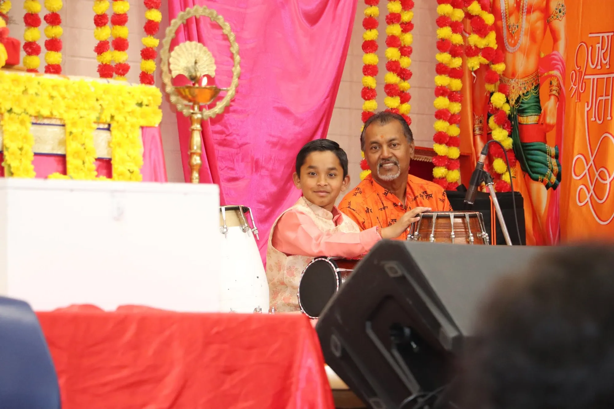 A boy at the keyboard beside the decorated stage