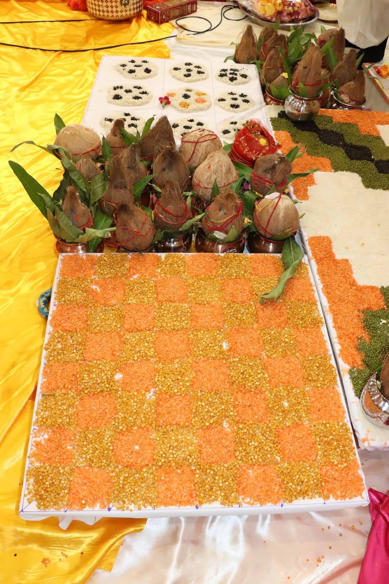 A close view of the grain rangoli, coconuts, and offerings on the vedi