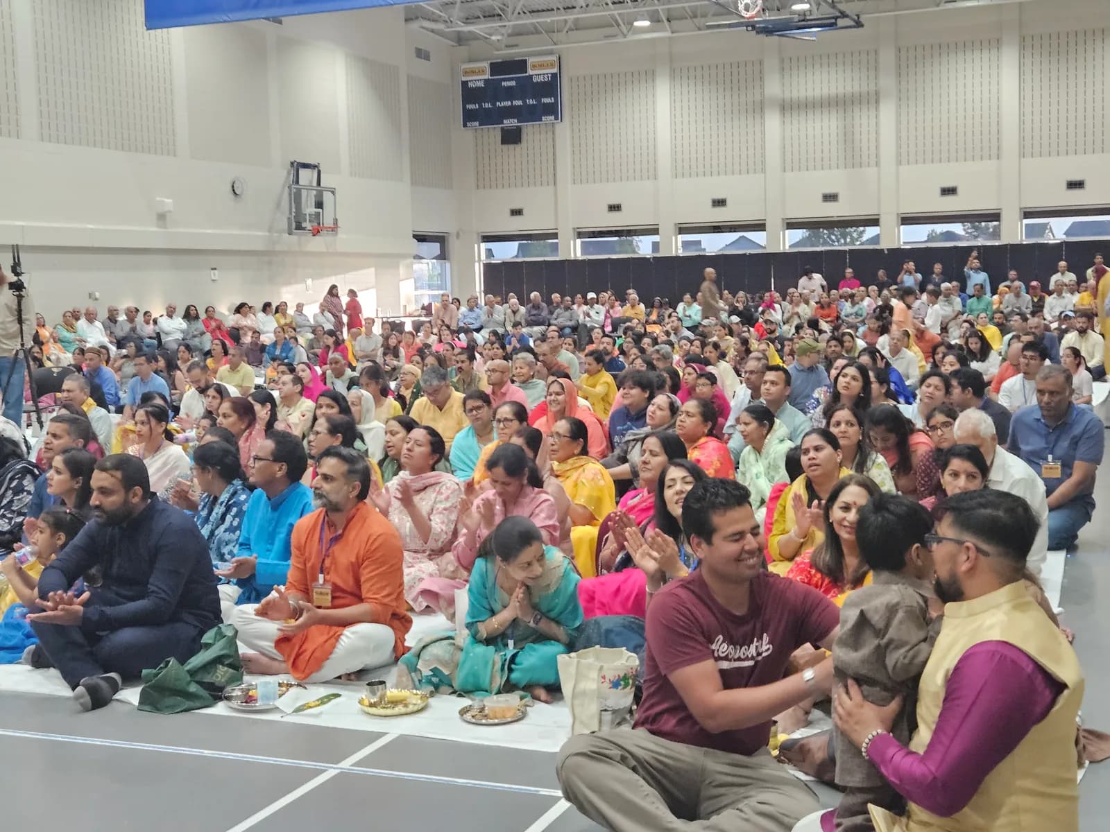 A packed hall of devotees seated for the katha