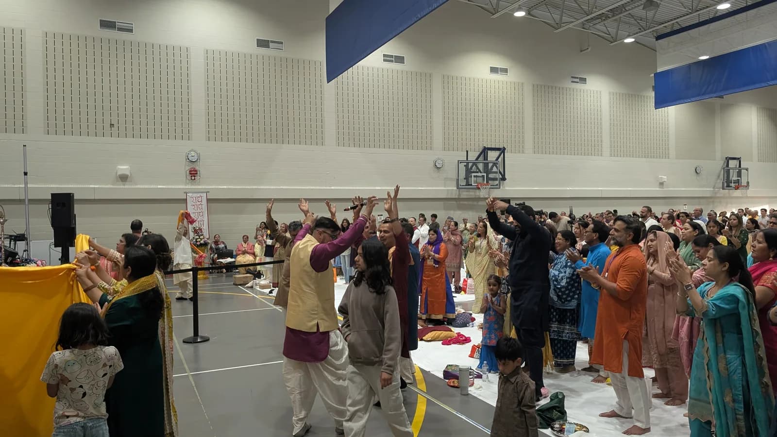 Devotees raise their hands and dance during the kirtan