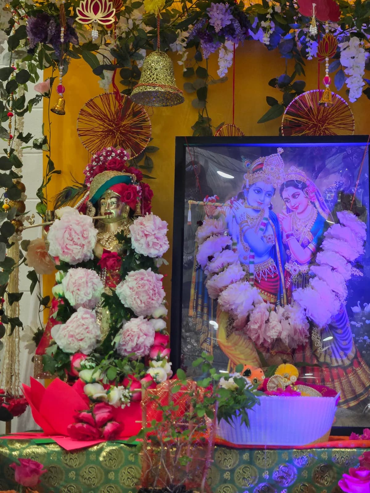 The framed deities of Radha and Krishna amid the flowers