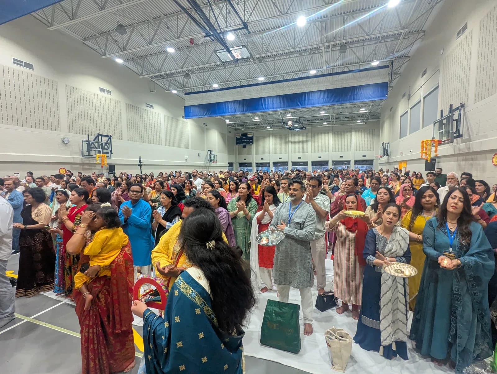 The sangat raises their hands during the aarti