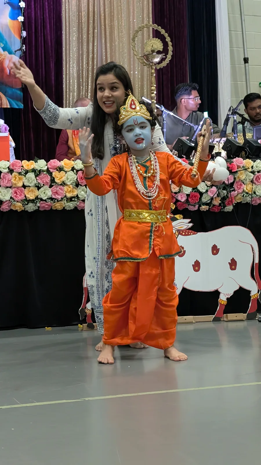 A young Krishna performs on stage